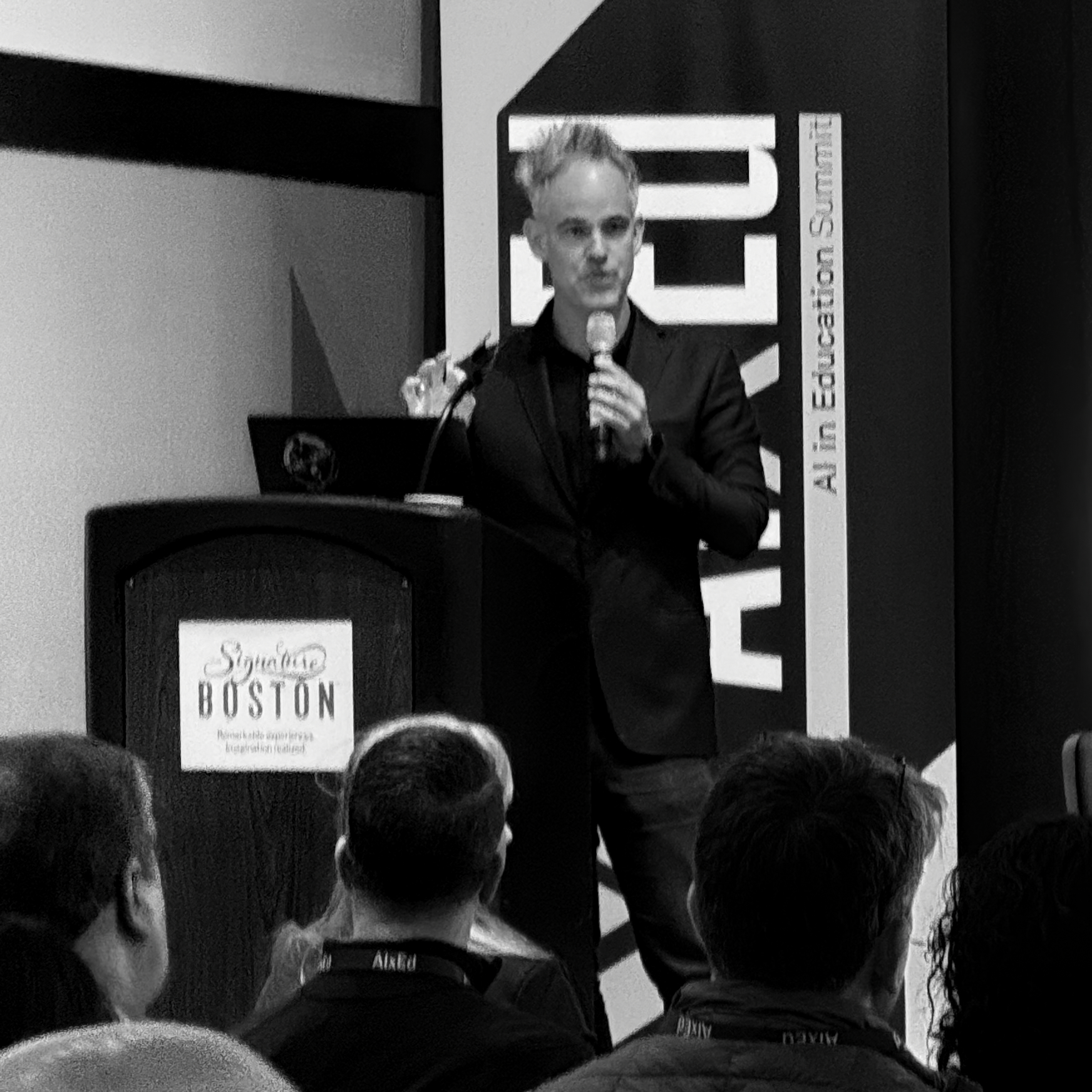 a black and white photo of a man speaking at a podium