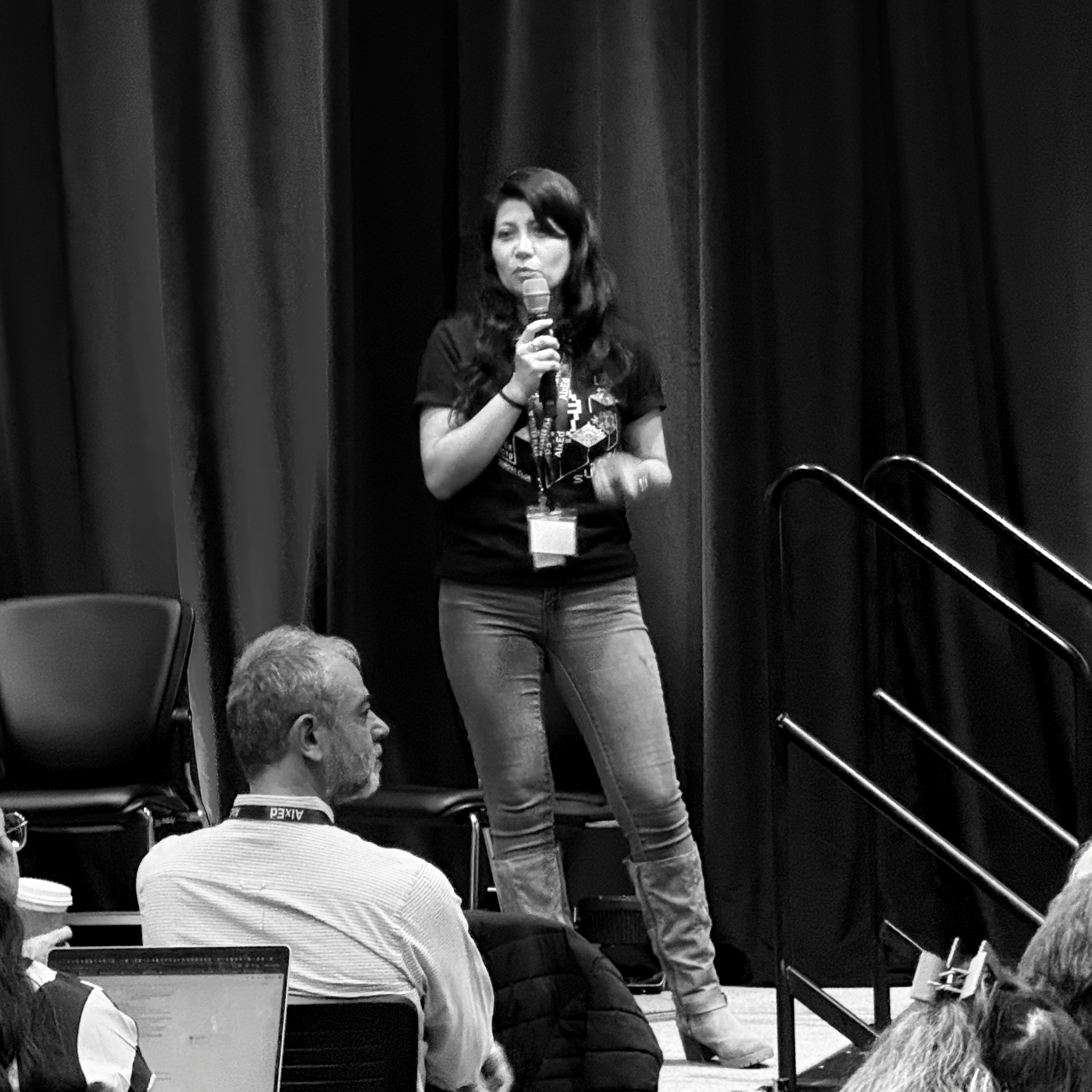 a black and white photo of a woman giving a presentation